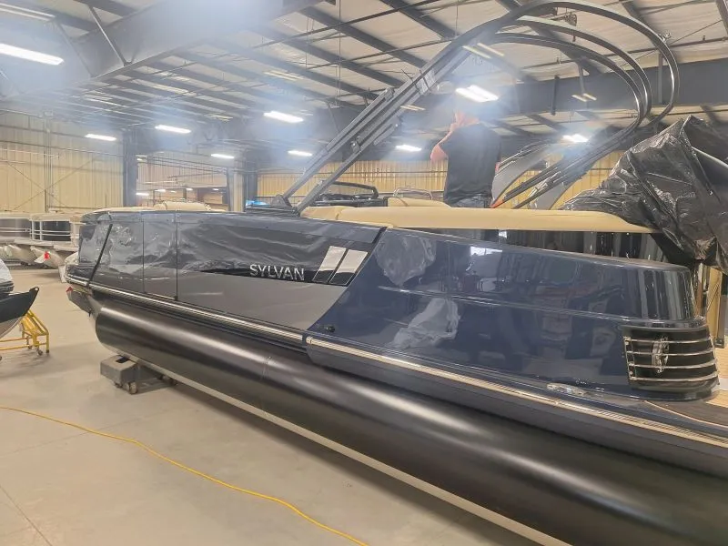Completed dark pontoon boat on a production floor