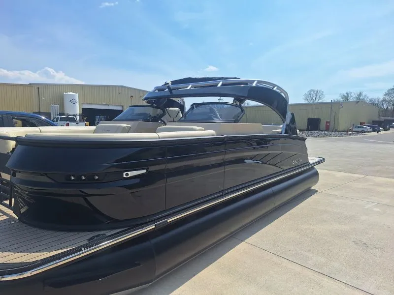 Finished dark pontoon boat shown outdoors in profile